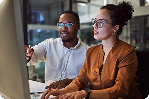 two coworkers looking at computer